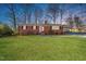 Charming brick ranch-style home featuring a well-manicured front yard and a convenient carport at 5013 Green Oak Dr, Durham, NC 27712