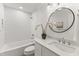 Modern bathroom features white subway tiles, a marble vanity, and a round mirror at 506 N Greensboro St # Apt 33, Carrboro, NC 27510