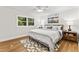 Bright bedroom features hardwood floors, ceiling fan, and a large window with natural light at 506 N Greensboro St # Apt 33, Carrboro, NC 27510