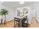 Bright dining area features a modern table, stools, a round mirror, and a view into the kitchen at 506 N Greensboro St # Apt 33, Carrboro, NC 27510