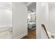 Hallway view of the bedroom and bathroom featuring neutral paint, hardwood floors, and white trim at 506 N Greensboro St # Apt 33, Carrboro, NC 27510