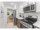 Bright kitchen with stainless steel appliances, tile backsplash, and an open view to the living area at 506 N Greensboro St # Apt 33, Carrboro, NC 27510