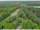Stunning aerial view showcasing the neighborhood with lush green forest, golf course, and lake at 5109 Windance Pl, Holly Springs, NC 27540