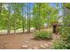 A lush backyard with mature trees, a stone path, and a wooden deck creates a serene outdoor retreat at 5109 Windance Pl, Holly Springs, NC 27540