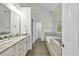 Bright bathroom with double vanity, soaking tub, and separate glass shower at 5109 Windance Pl, Holly Springs, NC 27540