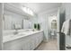 Bright bathroom with a double vanity, neutral paint, decorative plants, and wood-look tile at 5109 Windance Pl, Holly Springs, NC 27540