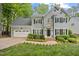 Charming two-story home with a well-manicured lawn and a two-car garage at 5109 Windance Pl, Holly Springs, NC 27540