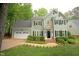 Charming two-story home with a manicured lawn and a two-car garage at 5109 Windance Pl, Holly Springs, NC 27540