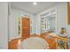 Bright foyer featuring hardwood floors, a wood front door, and views into an adjacent living space at 5109 Windance Pl, Holly Springs, NC 27540
