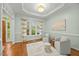 Bright living room with tray ceiling, hardwood floors, comfortable seating, and a large window at 5109 Windance Pl, Holly Springs, NC 27540