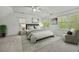 Bright bedroom with fan, sitting chair, and windows overlooking lush greenery at 5109 Windance Pl, Holly Springs, NC 27540