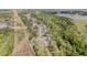 Aerial view displaying homes in a community amidst lush greenery, roads, and a distant lake at 5180 Glen Creek Trl, Garner, NC 27529