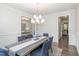 Formal dining room featuring blue upholstered chairs, an overhead chandelier, and wainscoting at 5180 Glen Creek Trl, Garner, NC 27529