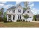 Beautiful white brick home with dark shutters, well-manicured landscaping, and a charming front porch sitting area at 5180 Glen Creek Trl, Garner, NC 27529