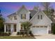 Charming two-story home features a white brick exterior, two-car garage, and beautifully landscaped front yard at 5180 Glen Creek Trl, Garner, NC 27529