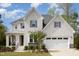 Charming two-story home features a white brick exterior, two-car garage, and beautifully landscaped front yard at 5180 Glen Creek Trl, Garner, NC 27529