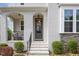 Inviting front porch with stylish seating and a well-maintained entrance, accented by elegant stone detailing and lush landscaping at 5180 Glen Creek Trl, Garner, NC 27529