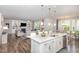 Open concept kitchen and living area with a fireplace, white cabinets, and a center island with a sink at 5180 Glen Creek Trl, Garner, NC 27529