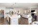 Open concept kitchen and living area with a pantry, white cabinets, and a granite-topped center island at 5180 Glen Creek Trl, Garner, NC 27529