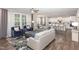 Spacious living room boasts hardwood floors, plush sofas, large windows, and an open-concept design connecting the kitchen at 5180 Glen Creek Trl, Garner, NC 27529