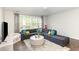 Relaxing living room featuring a comfortable gray sectional sofa, and large windows at 5180 Glen Creek Trl, Garner, NC 27529
