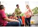 Relaxing porch view showing people laughing and enjoying drinks on a comfortable outdoor space at 540 Folk Song Way, Wendell, NC 27591