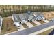 Aerial view of townhomes featuring well-kept landscaping, individual driveways, and nearby pond at 53 Whitley Ridge Dr, Clayton, NC 27527