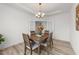 Dining area with wood table, bright light fixture, and open view through french doors at 53 Whitley Ridge Dr, Clayton, NC 27527