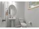 Powder room with pedestal sink, mirror, and toilet at 5432 Crescent Square St, Raleigh, NC 27616