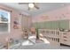 Bright Bedroom featuring a crib and playful decor, with pink walls and lots of toys at 5432 Crescent Square St, Raleigh, NC 27616