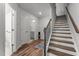 Bright entryway showcasing wood floors, staircase and a convenient half bathroom at 5432 Crescent Square St, Raleigh, NC 27616