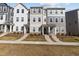 Street view of modern townhomes with stone accents and landscaped yards at 5432 Crescent Square St, Raleigh, NC 27616