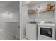 Upstairs laundry room with side by side washer and dryer plus storage shelves at 5432 Crescent Square St, Raleigh, NC 27616