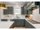 Stylish kitchen with green cabinets, stainless steel appliances, white countertops and backsplash at 548 Folk Song Way, Wendell, NC 27591