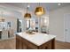 Kitchen island with seating and view into connected dining and living areas with fireplace at 548 Folk Song Way, Wendell, NC 27591