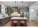 Modern kitchen featuring green cabinets, stainless steel appliances, and a central island with stool seating at 548 Folk Song Way, Wendell, NC 27591