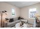 Cozy living room featuring a comfortable gray sofa, neutral wallpaper, and sunlit windows for a relaxing atmosphere at 548 Folk Song Way, Wendell, NC 27591