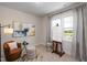 Bright studio space with an easel, modern chair, neutral walls, and natural light streaming through a large window at 548 Folk Song Way, Wendell, NC 27591