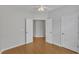 Bedroom with hardwood floors, a ceiling fan, and double doors enhancing the room's brightness and openness at 563 Tomkins Loop, Cary, NC 27519