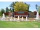 Community entrance featuring brick, stone, mature landscaping, and water features at 563 Tomkins Loop, Cary, NC 27519