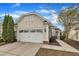 Charming home featuring an attached two-car garage with a white door and beautiful, well-maintained landscaping at 563 Tomkins Loop, Cary, NC 27519