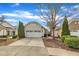 Charming home featuring an attached two-car garage with a white door and beautiful, well-maintained landscaping at 563 Tomkins Loop, Cary, NC 27519