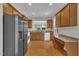 Spacious kitchen featuring wooden cabinets, granite countertops, stainless steel appliances, and hardwood floors at 563 Tomkins Loop, Cary, NC 27519