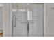 Bright shower with sleek glass doors, grab bars, and built-in shelving, providing a clean and accessible design at 563 Tomkins Loop, Cary, NC 27519