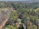 Aerial view of a home nestled in a forest with a pool and long driveway at 5816 Sand Pebble Pl, Raleigh, NC 27613