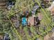 Aerial view of a private home with a pool surrounded by lush trees and a long driveway at 5816 Sand Pebble Pl, Raleigh, NC 27613