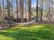 Landscaped backyard showcasing a hammock, green grass, and black metal fence at 5816 Sand Pebble Pl, Raleigh, NC 27613
