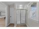 Bright bathroom showcasing a glass door shower, window, and doorway with neutral paint at 5816 Sand Pebble Pl, Raleigh, NC 27613