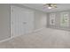 Spacious bedroom with neutral carpet, ceiling fan and natural light from two windows at 5816 Sand Pebble Pl, Raleigh, NC 27613