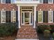 Inviting front entrance with brick steps, white columns, and a glass storm door at 5816 Sand Pebble Pl, Raleigh, NC 27613